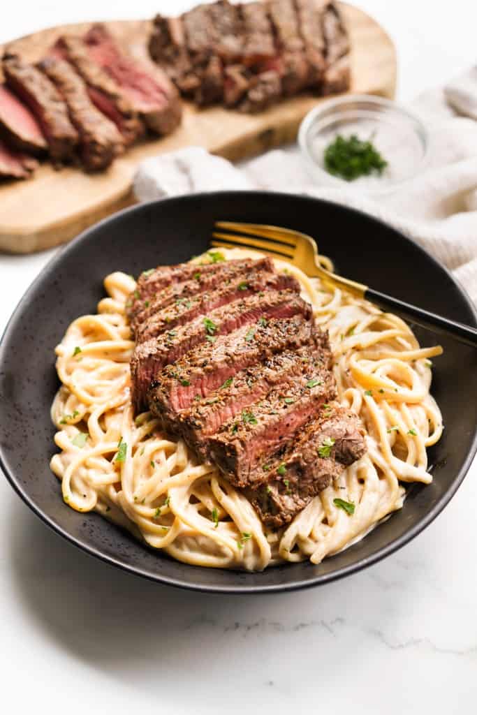 A bowl is filled with creamy steak pasta.