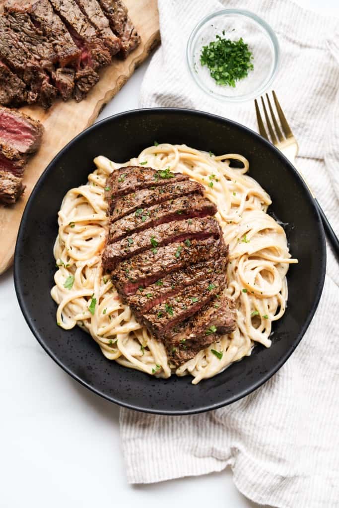 Top down picture of a bowl full of steak and pasta.