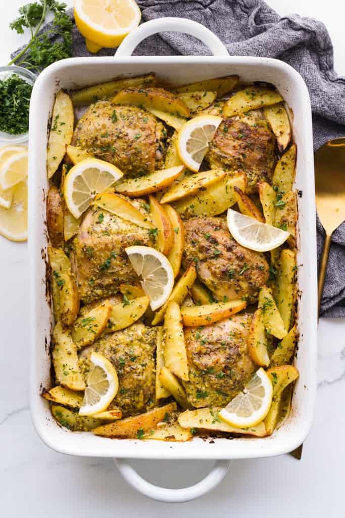 A 9"x13" baking dish is filled with Baked Greek Lemon chicken and potatoes.