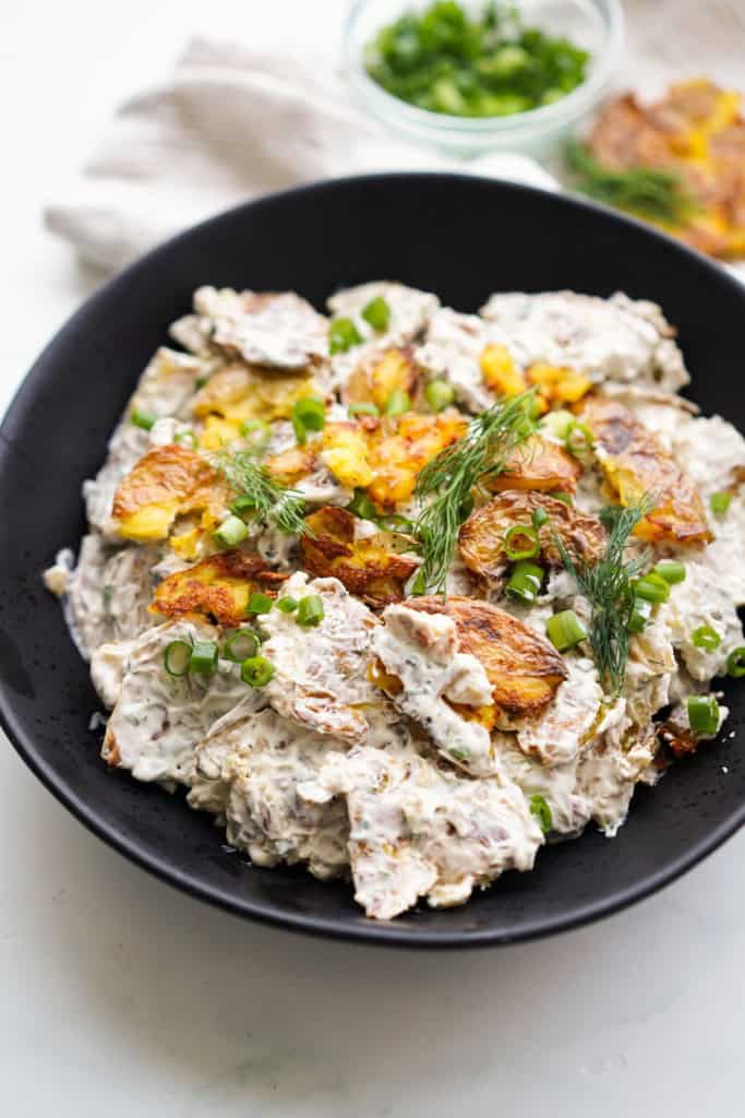 Crispy Potato Salad is topped with fresh dill and green onions.