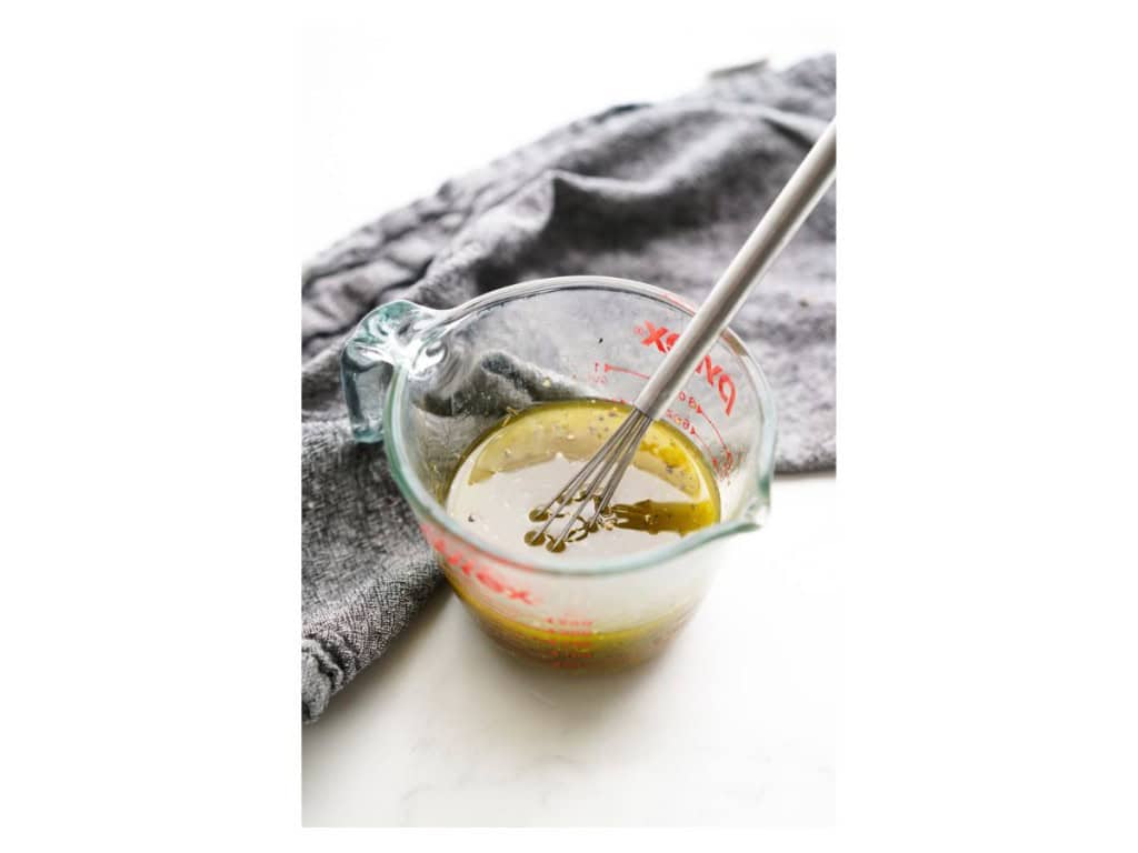 The dressing ingredients are added to a small measuring cup and whisked together.