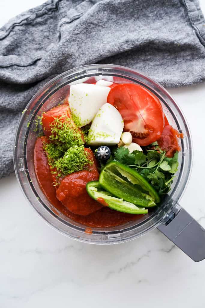 All of the ingredients are roughly chopped and added the the bowl of a food processor.