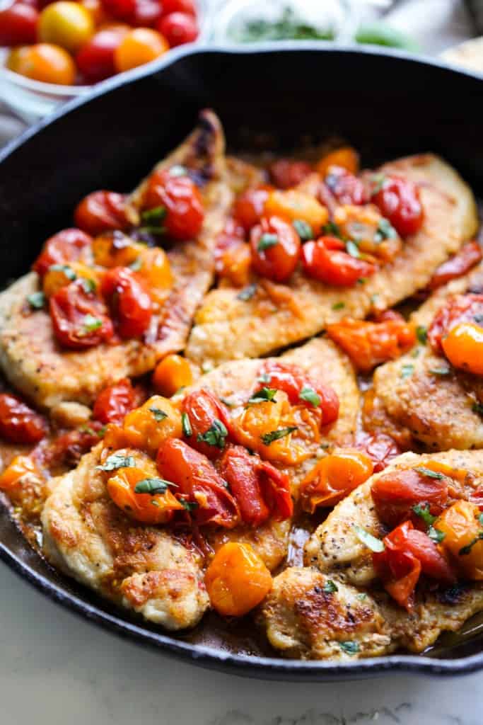 Chicken and tomatoes in a cast iron skillet makes an easy one pan dish.