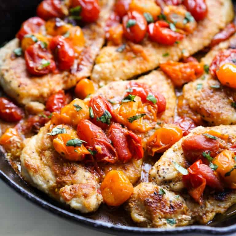 Close up picture of Skillet chicken with blistered tomatoes.