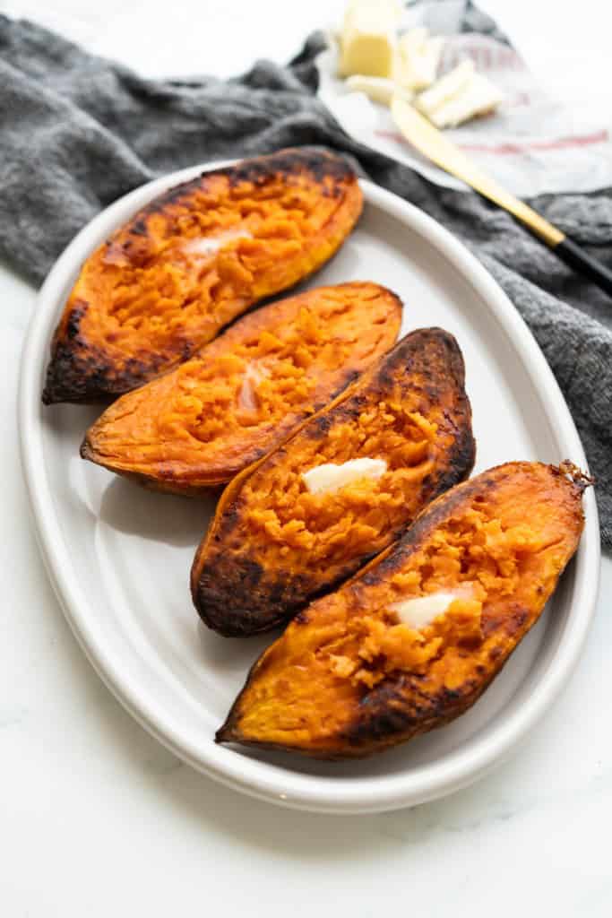 A plate is filled with caramelized baked sweet potatoes.
