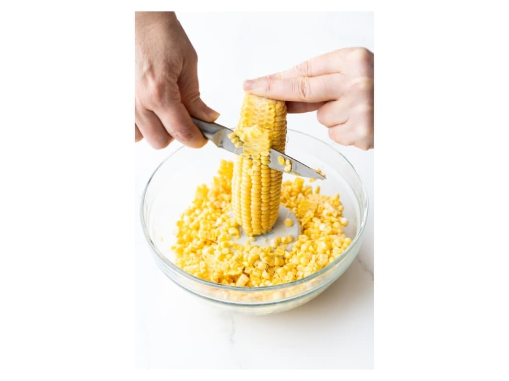Corn kernels are cut off of the corn cob.