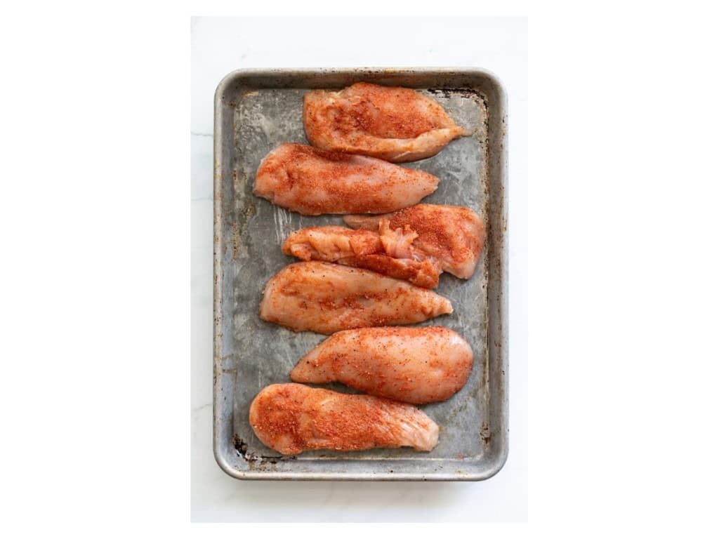 Chicken breasts are halved length wise and generously seasoned on both sides.