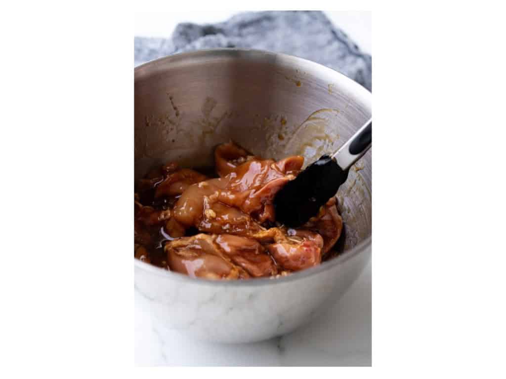Chicken thighs are coated in the marinate.