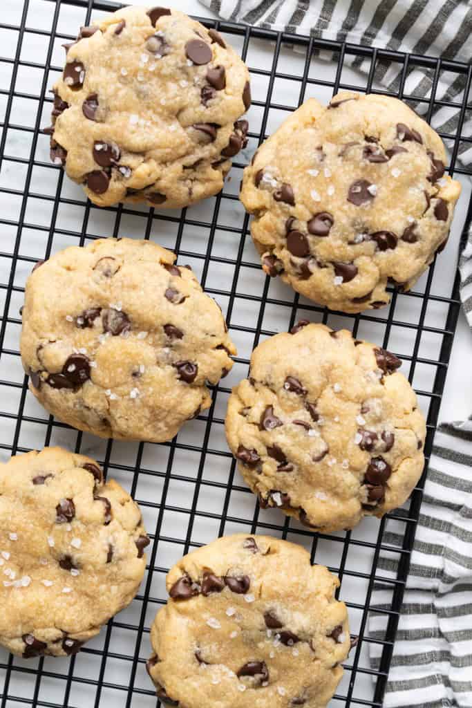 6 giant chocolate chips are salted and sitting on a cooling rack.