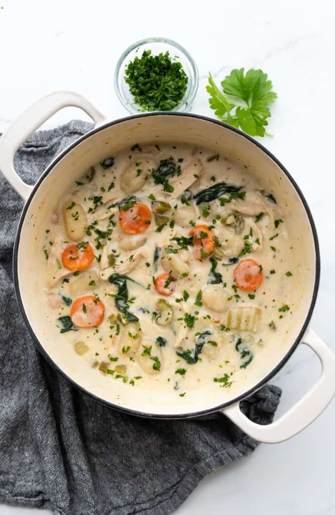 A Dutch oven is filled with Cream of Chicken Gnocchi Soup.
