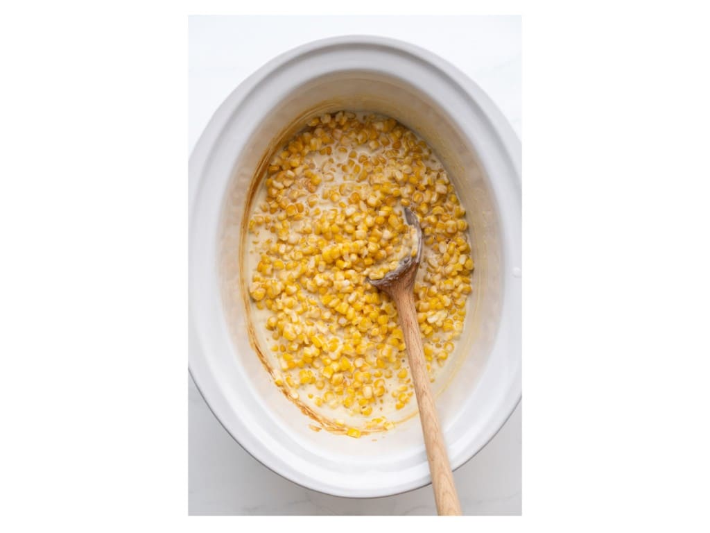 After cooking for two hours, stir the creamed corn and add salt.